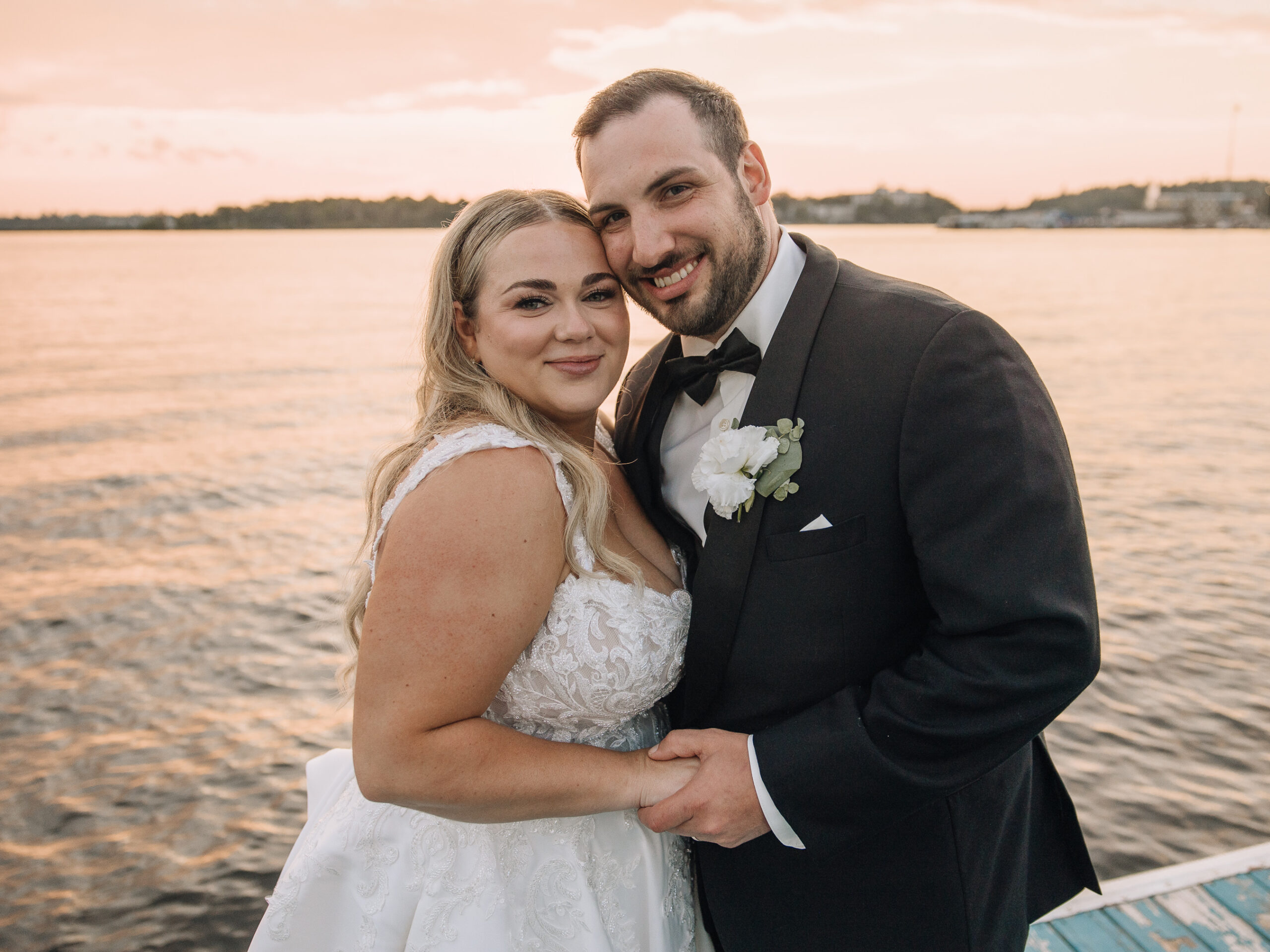 Bride and groom laughing during their Manitoba wedding portraits at sunset
